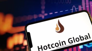 Konskie, Polonya - 05 Ocak 2024: Hotcoin Global kripto döviz logosu şifreleme pazarının arka planında akıllı telefonda gösterildi