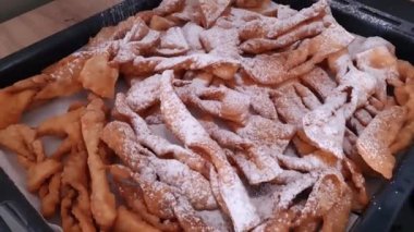 Taze yapılmış melek kanatlı kurabiyeler pudra şekerli, Şişko Perşembe için bir yemek.