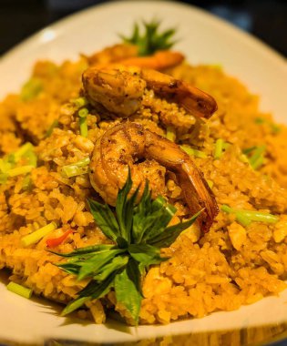 Shrimp fried rice served in a white bowl with fresh herbs. Great for seafood, Asian cuisine, and gourmet food concepts.