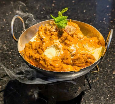 Delicious butter chicken curry served in traditional bowls, garnished with fried onions, cream, and fresh mint leaves. A rich, creamy, and flavorful Indian dish perfect for food backgrounds, menus, and recipe concepts.