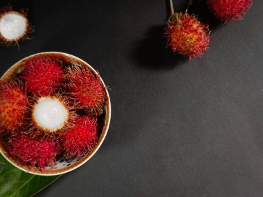 tatlı ve taze tropikal meyveli rambutan siyah bir zemin üzerinde otururken fotokopi alanı ile