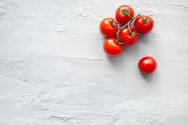 Gri arka planda taze vişneli domatesler, üst manzara. Boşluğu kopyala, metin için boşluk. 