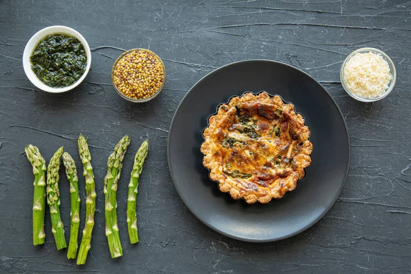 Traditional vegetable tart quiche with asparagus and cheese, top view. 
