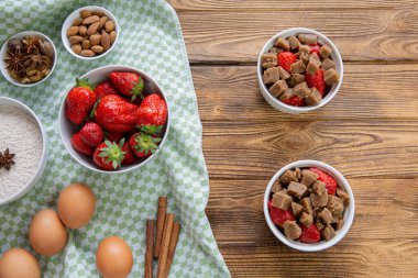 Homemade strawberry summer pie preparation. Baking ingredients on rustic wooden table, top view. 