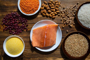 Ahşap arka planda protein yiyeceği, üst manzara. Somon, fasulye ve tahıl çeşitleri.. 