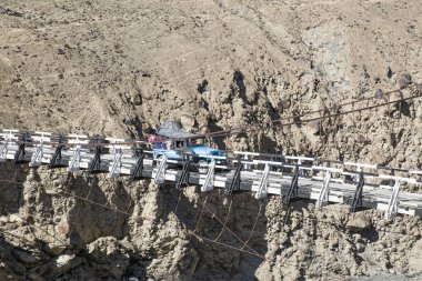 Shimshal köyüne giden asma köprüde bir cip var. Rocky Karakoram Dağları. 