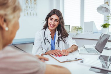 Doktor ve hasta hastanede masada otururken bir şey tartışıyorlar..