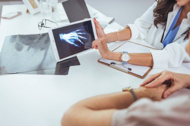 Doktor ve hasta hastanede oturup röntgenleri tartışıyorlar..