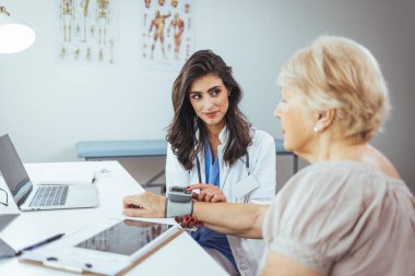 Kadın doktor hastanede kan basıncını ölçüyor.