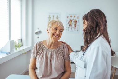 Doktor yaşlı kadına hemşirelik tavsiyesi veriyor.