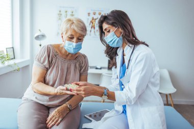 Kadın doktor, hastanedeki kıdemli hastasına ilaç veriyor.