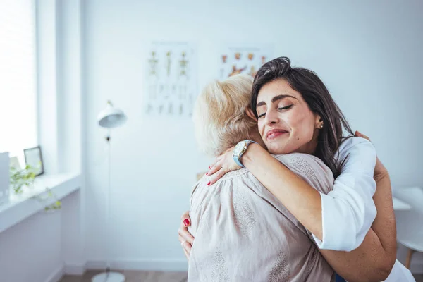 Portrait Cheerful Female Doctor Hugging Her Senior Patient Clinic — Stock Photo, Image