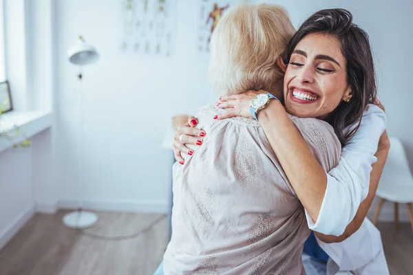Portrait Cheerful Female Doctor Hugging Her Senior Patient Clinic — Stock Photo, Image