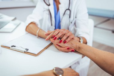Kadın doktor, kadın sağlık hizmetleri konsepti olarak toplantıda kadın hastanın elini tutuyor. Düşükle ilgili güven desteği empati kuruyor, kanser hastalıkları terapisinde umuda yardımcı oluyor, görüşü kapatıyor.