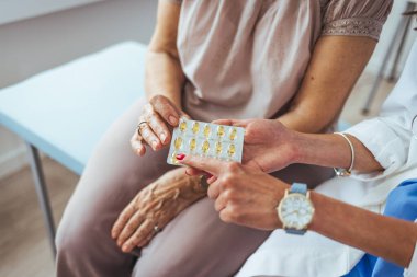Doktor ya da doktor yaşlı kadın hasta hastanesi ve tıp konseptine ilaç öneriyor. Olgun kadın doktor, hastane odasında hastaya danışmanlık yapıyor. Doktor ve hasta ofiste sağlık sorununu tartışıyor.