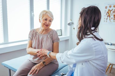 Dost canlısı kadın doktorların elleri cesaretlendirmek ve empati kurmak için kadın hastaların elini tutuyor. Ortaklık güveni ve tıbbi etik kavramı. Doktor umut veriyor.. 
