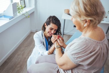 Yaşlılarla ilgilenmenin işareti. Yardım eli uzatıyorum. Yaşlılara özen gösterin. Mutlu ve yaşlı bir kadınla ilgilenen kadın bir doktor. Sağlık ziyaretçisi ve yaşlı bir kadın. 