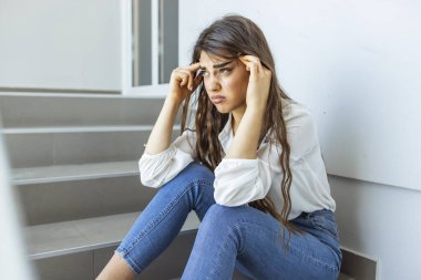 İş kadını iş yerinde merdivenlerde otururken strese giriyor, konsept iş hayatı dengesi, yanma sendromu, iş arkadaşlarının baskısı.