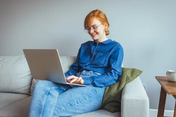 Ung Kvinna Med Laptop Och Glasögon Sitter Soffan Hemma — Stockfoto