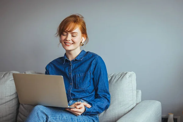 Młoda Kobieta Laptopem Okularami Siedząca Kanapie Domu — Zdjęcie stockowe