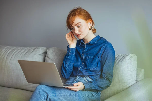Młoda Kobieta Laptopem Okularami Siedząca Kanapie Domu — Zdjęcie stockowe