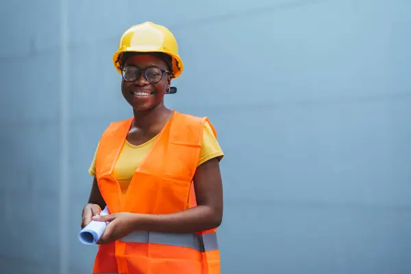 young african - american worker in yellow safety hat and vest