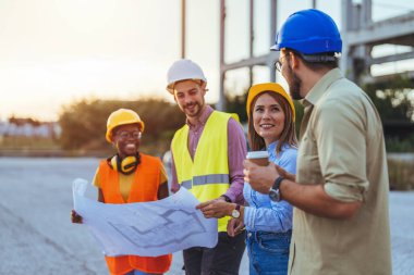 İnşaat alanındaki planlara bakan bir grup mühendis