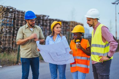 İnşaat alanındaki planlara bakan bir grup mühendis