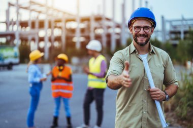 Mimarlık şirketi inşaat alanının planlarını katlamış.