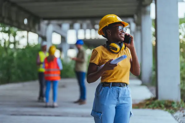 African worker using smartphone on construction site