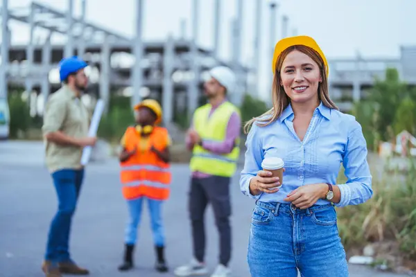 Architect holding cup of coffee at construction site