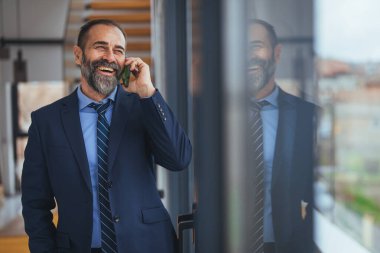 Ofiste akıllı telefondan konuşan Kafkasyalı iş kadını