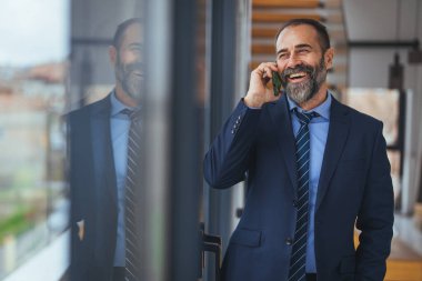 Ofiste akıllı telefondan konuşan Kafkasyalı iş kadını