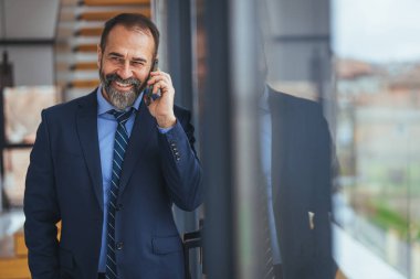 Ofiste akıllı telefondan konuşan Kafkasyalı iş kadını