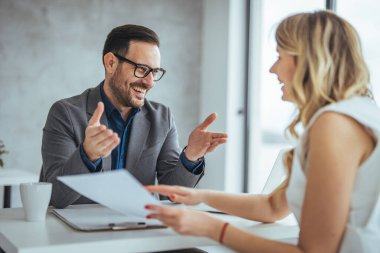 İşadamı ve iş kadını ofiste çalışırken tartışıyorlar.