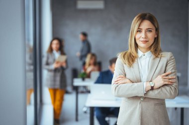 İş kadını portresi toplantı odasında duruyor ve arka planda iş arkadaşları dağıtıyor. Modern iş kadınının belini bük ve fotokopi çektir.