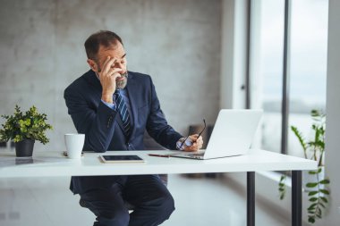 Bitkin hissediyorum. Hüsrana uğramış, olgun sakallı bir adam. Ofisinde otururken burnuna masaj yapıyor ve gözlerini kapalı tutuyor. Ofiste dizüstü bilgisayarı izleyen hayal kırıklığına uğramış bir iş adamı.