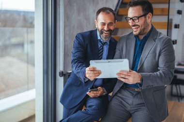 Ofiste tartışan iki iş adamını vurdu. Takım çalışması, çeşitlilik ve satış müdürü, ofisteki bir tablette yaratıcı bir tasarımcıyla fikir üretmeyi planlıyor..