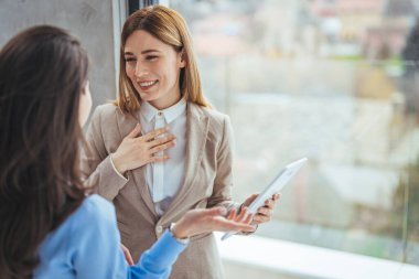 Portrait of two young business woman having a meeting or presentation and seminar standing in the office. Portrait of a young business woman talking. 