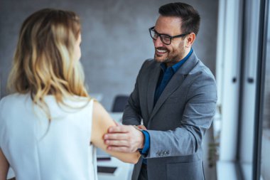 İş kadını adayları toplantıda başarılı bir şekilde gülümseyerek el sıkışıyor, yeni bir işe girdiği için tebrik ediyor, müşteri ve çeşitli iş ortaklarıyla harika bir anlaşma yapıyor.