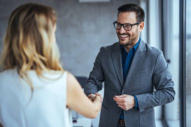 Ofiste el sıkışan iki iş adamının vurulması. Başarılı bir pazarlıktan sonra gülümseyen iş adamları tokalaşır. Yeni anlaşma için el sıkışma.