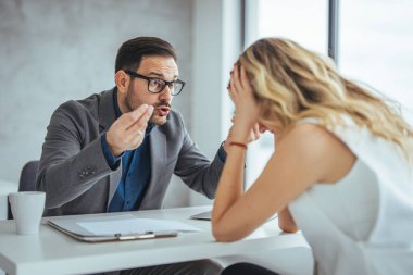Patron, çalışanını parmakla tehdit ediyor. Kızgın kaba patron çalışana son teslim tarihini kaçırdığı için bağırıyor, yönetici müdürü kötü iş sonuçlarını gösteren beceriksiz satış elemanını azarlıyor, başarısız olduğu için işçileri kovuyor.