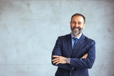 Kameraya bakan mutlu bir iş adamının portresi. Çok ırklı, tatmin olmuş, sakallı, kendine güvenen bir adam. Başarılı bir Orta Doğulu iş adamı yaratıcı bir ofiste gülümsüyor.