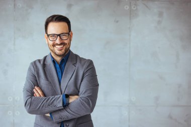 Gözlüklü genç iş adamının portresi ve konferans salonunun önünde dikilmesi. Gözlüklü mutlu iş adamının portresi ve fotokopi çekilen kameraya bakmak. Memnun olmuş gururlu bir adam modern bir ofiste kendine güveniyor..