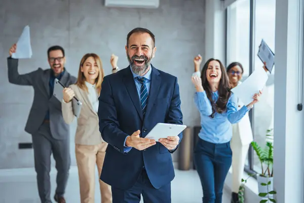 Portrait of overjoyed young diverse employees workers show thumb up recommend good quality company service. Smiling multiethnic colleagues celebrate shared business success or victory in office