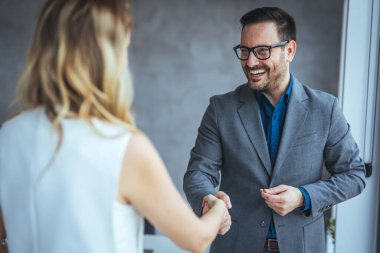 Anlaşmayı mühürlüyorum! Karşılama ortakları toplantılarını bitirdikten ya da hedefler belirledikten ve ofiste başarıya giden yolu planladıktan sonra el sıkışan iki iş adamı. İş adamları ofiste el sıkışıyor.. 