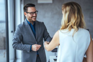 Anlaşmayı mühürlüyorum! Karşılama ortakları toplantılarını bitirdikten ya da hedefler belirledikten ve ofiste başarıya giden yolu planladıktan sonra el sıkışan iki iş adamı. İş adamları ofiste el sıkışıyor.. 
