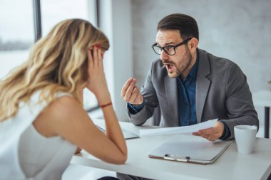 Patron, çalışanını parmakla tehdit ediyor. Kızgın kaba patron çalışana son teslim tarihini kaçırdığı için bağırıyor, yönetici müdürü kötü iş sonuçlarını gösteren beceriksiz satış elemanını azarlıyor, başarısız olduğu için işçileri kovuyor.