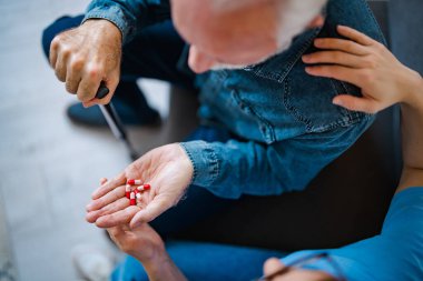 Kadın doktor evdeki yaşlı erkek hastaya reçete yazıyor. Kadın pratisyen hekim şişesi hapları olgun bir müşteriye reçeteli ilaç veriyor. Yaşlılar için sağlık hizmeti kavramı.