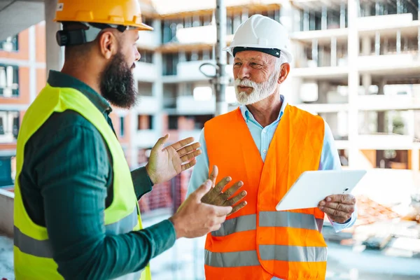 Zwei Ingenieure Unterhalten Sich Während Der Arbeit Auf Der Baustelle — Stockfoto